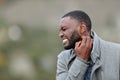 Stressed man with black skin scratching neck in winter Royalty Free Stock Photo