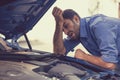 Stressed man with broken car looking at failed engine Royalty Free Stock Photo