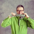 Stressed man in green shirt and glasses biting in his necktie Royalty Free Stock Photo