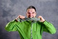 Stressed man in green shirt pink glasses biting in his necktie Royalty Free Stock Photo