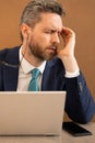 Stressed man with headache. Tired businessman is working overtime and has headache. Man with laptop at workplace Royalty Free Stock Photo