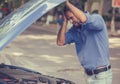 Stressed man with his broken car looking in frustration at failed engine Royalty Free Stock Photo