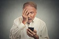 Stressed man holding cellphone shocked with message received Royalty Free Stock Photo