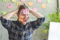 Stressed man with message on sticky notes over his face in office. Royalty Free Stock Photo