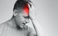 Stressed man suffering from migraine, touching his red forehead Royalty Free Stock Photo