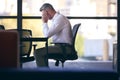 Stressed Mature Businessman Working On Laptop Sitting At Boardroom Table