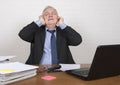 Stressed mature man at work covering his ears