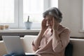 Stressed mature senior woman touching head with closed eyes Royalty Free Stock Photo