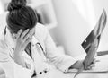 Stressed medical doctor woman with fluorography in office