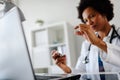 Stressed medical worker working at her office taking pill