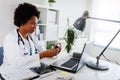 Stressed medical worker working at her office taking pill