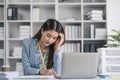 Stressed millennial Asian businesswoman or female manager having a serious use laptop with her business client while Royalty Free Stock Photo