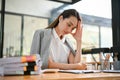 Stressed Asian businesswoman focusing on her task, planning strategy to solve business`s problems