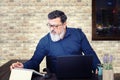 Stressed mixed race senior entrepreneur at desk working late in office Royalty Free Stock Photo