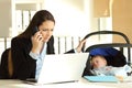 Stressed mother working taking care of her baby at office Royalty Free Stock Photo