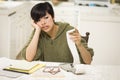 Stressed Multi-ethnic Young Woman Agonizing Over Financial Calculations