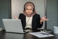 A stressed Muslim female customer support operator is having a stressful conversation over the phone Royalty Free Stock Photo