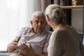 Stressed old man sharing problems with compassionate elderly wife.