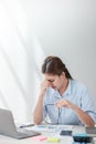 Stressed out Asian Business woman using calculator and laptop for doing math finance on an office desk, tax, report Royalty Free Stock Photo