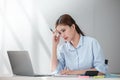 Stressed out Asian Business woman using calculator and laptop for doing math finance on an office desk, tax, report Royalty Free Stock Photo