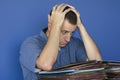 Stressed out man at work in front of a pile of files. Royalty Free Stock Photo