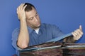 Stressed out man at work reading through files. Royalty Free Stock Photo