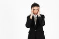 Stressed overworked and confused young Asian business woman in suit troubled with financial problem over white isolated background Royalty Free Stock Photo