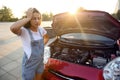 Stressed pregnant woman standing near broken car on city street Royalty Free Stock Photo