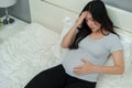 Stressed pregnant woman suffering headache lying in bed Royalty Free Stock Photo