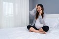 Stressed pregnant woman talking on a mobile phone in bed Royalty Free Stock Photo