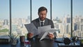 Stressed professional throwing papers in cityscape office. Upset man thinking Royalty Free Stock Photo