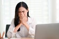 Stressed and sad Asian businesswoman crying at her desk, upset with herself Royalty Free Stock Photo