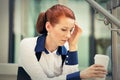 Stressed sad young woman with coffee cup sitting outdoors. City urban life style stress Royalty Free Stock Photo