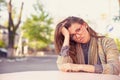 Stressed sad young woman sitting outdoors. Royalty Free Stock Photo