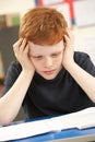 Stressed Schoolboy Studying In Classroom Royalty Free Stock Photo