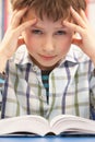 Stressed Schoolboy Studying In Classroom