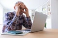 Stressed senior caucasian man working with laptop at home feeling overwhelmed. Royalty Free Stock Photo