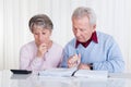 Stressed senior couple calculating budget