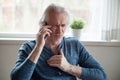 Stressed senior man having heart attack while talking on phone Royalty Free Stock Photo