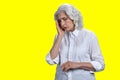 Stressed senior woman suffering from migraine on yellow background. Royalty Free Stock Photo