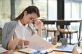 Stressed and serious Asian businesswoman examining report, worried about her project`s deadline Royalty Free Stock Photo