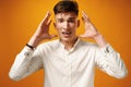 Stressed shouting young man holding hands near his head Royalty Free Stock Photo