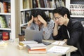Stressed students preparing for examination in library Royalty Free Stock Photo
