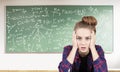 Stressed teen girl and formulas on blackboard