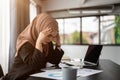 A stressed and thoughtful Asian Muslim businesswoman is examining reports with a serious face Royalty Free Stock Photo