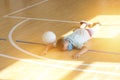 Stressed tired exhausted child with blue mask and  ball in a physical education lesson. Safe back to school during pandemic concep Royalty Free Stock Photo