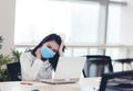 Stressed  and tired young  business woman wear face mask working on laptop Royalty Free Stock Photo