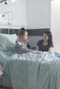 Stressed uneasy parent talking to injured ill little daughter while sitting in pediatric clinic recovery ward room.