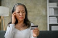 Unhappy Asian mature woman having financial problems or problems with her credit card Royalty Free Stock Photo