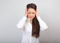 Stressed unhappy business woman with head pain closed ears the hands because not want the hear any sounds